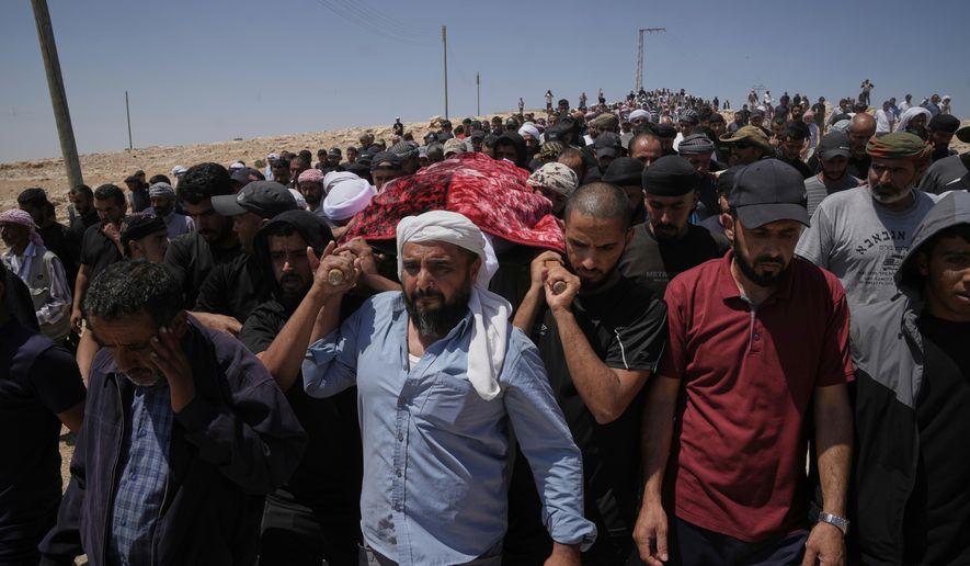 FILE - Mourners carry the body of Palestinian activist Awdah Hathaleen during his funeral in the West Bank Bedouin village of Umm al-Khair, Aug. 7, 2025. (AP Photo/Mahmoud Illean, file)