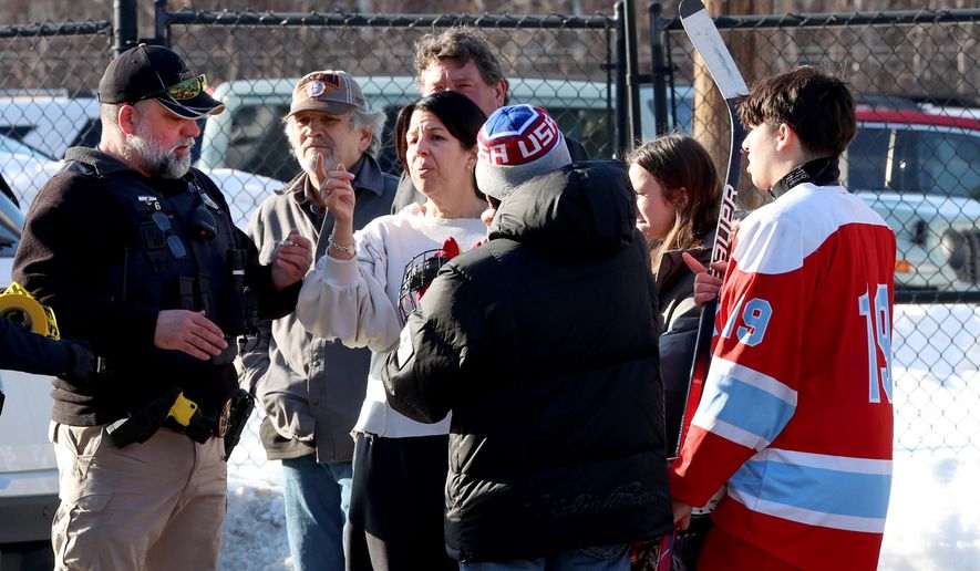 Hockey parents and a player speak to a police officer outside of the Lynch Arena in Pawtucket, R.I., after a shooting at the ice rink, Monday, Feb. 16, 2026. (AP Photo/Mark Stockwell)