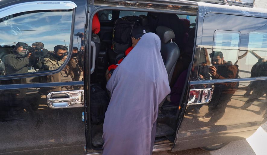 Family members of suspected Islamic State militants who are Australian nationals board a van heading to the airport in Damascus during the first repatriation operation of the year, at Roj Camp in eastern Syria, Monday, Feb. 16, 2026. Thirty-four Australian citizens from 11 families departed the camp. (AP Photo/Baderkhan Ahmad)