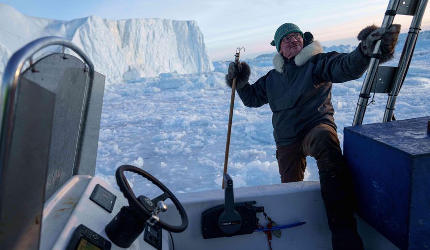 Jørgen Kristensen gets on a boat by an iceberg at Disko Bay near Ilulissat, Greenland, Thursday, Jan. 29, 2026. (AP Photo/Evgeniy Maloletka)