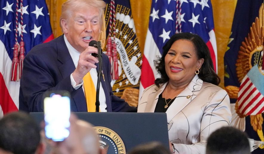 President Donald Trump speaks as White House pardon czar Alice Johnson listens during a Black History Month event in the East Room of the White House, Wednesday, Feb. 18, 2026, in Washington. (AP Photo/Nathan Howard)