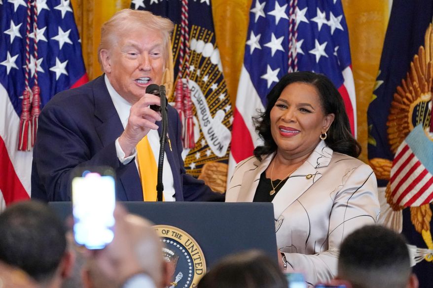 President Donald Trump speaks as White House pardon czar Alice Johnson listens during a Black History Month event in the East Room of the White House, Wednesday, Feb. 18, 2026, in Washington. (AP Photo/Nathan Howard)