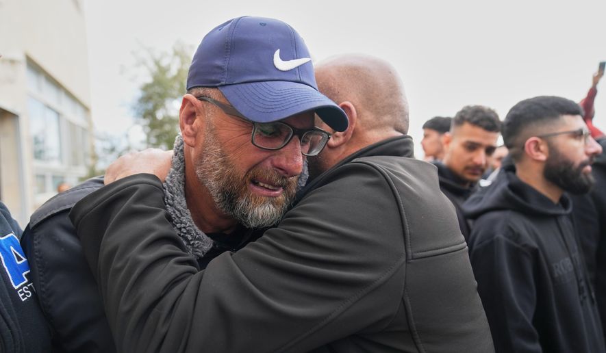 Mourners give condolences to Mohammad Abu Siyam, the father of Palestinian-American Nasrallah Abu Siyam, 19, who according to the Palestinian Health Ministry was shot by settlers on Wednesday night, during his funeral in the West Bank village of Mukhmas, east of Ramallah, Thursday, Feb. 19, 2026. (AP Photo/Nasser Nasser)