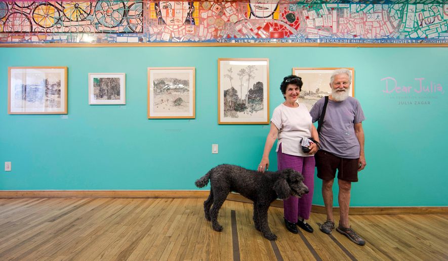 FILE - Julia Zagar, left, and her husband Isaiah Zagar pose for a photo with their dog Blue at the "Dear Julia" exhibit at Philadelphia's Magic Gardens May 26, 2016, in Philadelphia. (AP Photo/Matt Rourke, File)