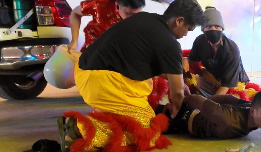 In this image released by Thailand’s Metropolitan Police Bureau, Thai police disguised as lion dance performers catch a burglary suspect at a temple fair in Nonthaburi province, Wednesday, Feb. 18, 2026. (The Metropolitan Police Bureau via AP)