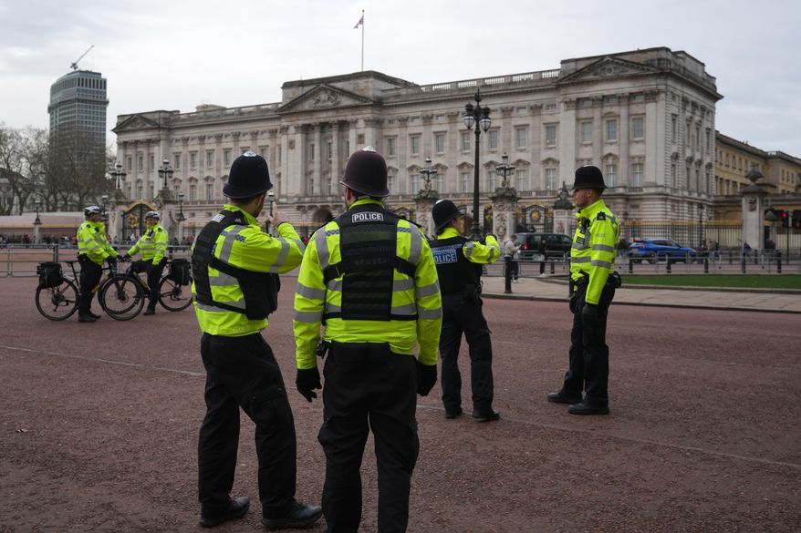 Police officers stand in front of Buckingham Palace in London, Friday, Feb. 20, 2026. (AP Photo/Kin Cheung) ** FILE **
