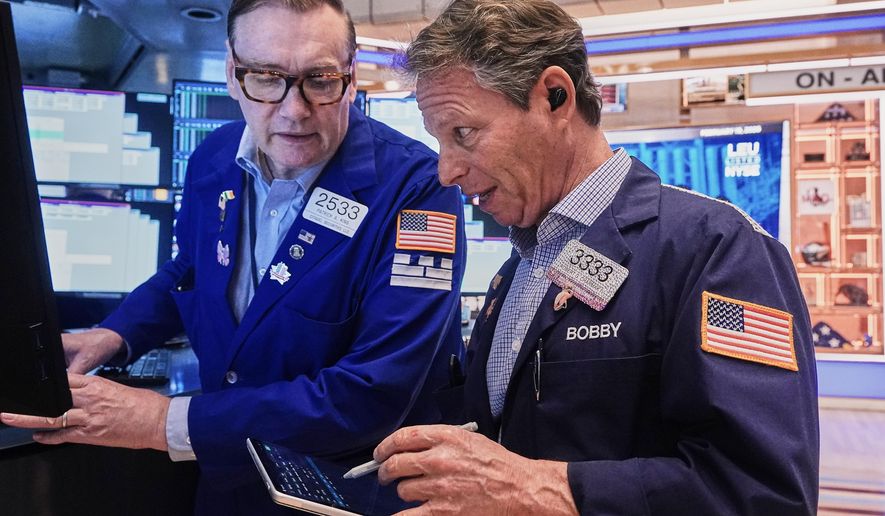 Specialist Patrick King, left, and trader Robert Charmak work on the floor of the New York Stock Exchange, Thursday, Feb. 19, 2026. (AP Photo/Richard Drew)