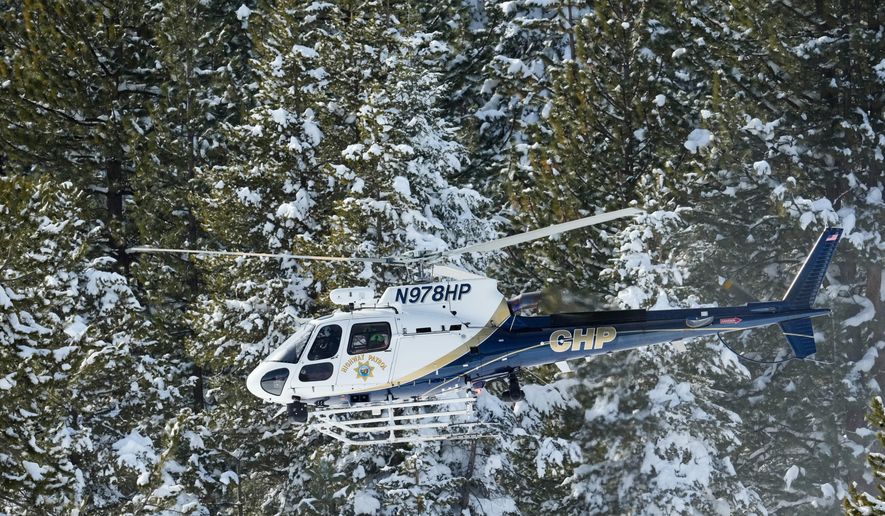 A California Highway Patrol search and rescue crew flies over a forest as recovery efforts for a group of missing skiers continue Friday, Feb. 20, 2026, in Truckee, Calif. (AP Photo/Godofredo A. Vásquez)