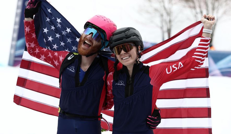 United States' Anna Gibson, left, and United States' Cameron Smith celebrate at the finish area of a ski mountaineering mixed relay, at the 2026 Winter Olympics, in Bormio, Italy, Saturday, Feb. 21, 2026. (AP Photo/Gabriele Facciotti)