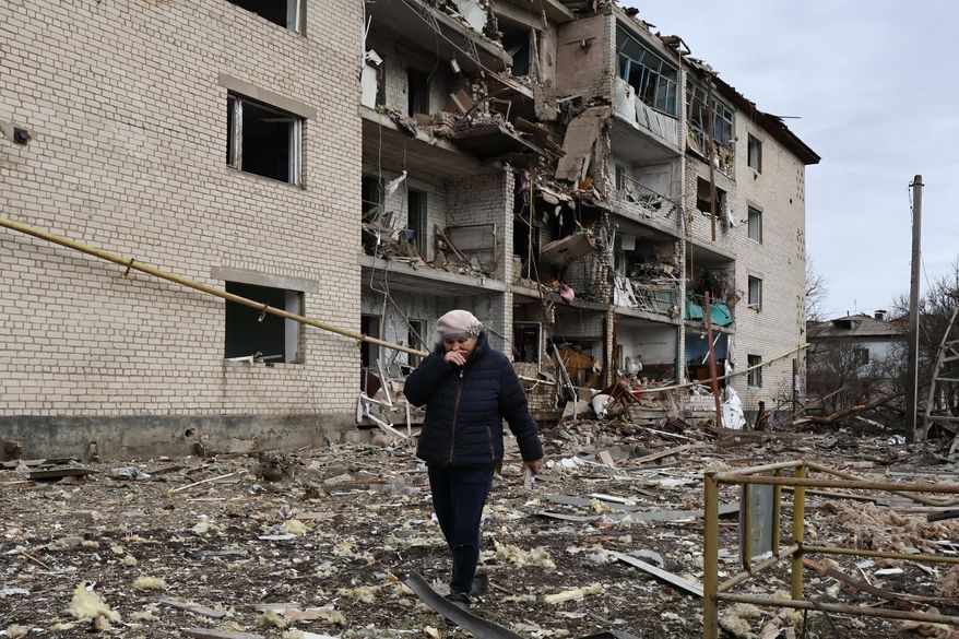 In this photo provided by Ukraine's 65th Mechanized Brigade press service, a local passes by a destroyed apartment building following an Russian air strike in the town of Komyshuvakha in the Zaporizhzhia region of Ukraine, Friday, Feb. 20, 2026. (Andriy Andriyenko/Ukraine's 65th Mechanized Brigade via AP)