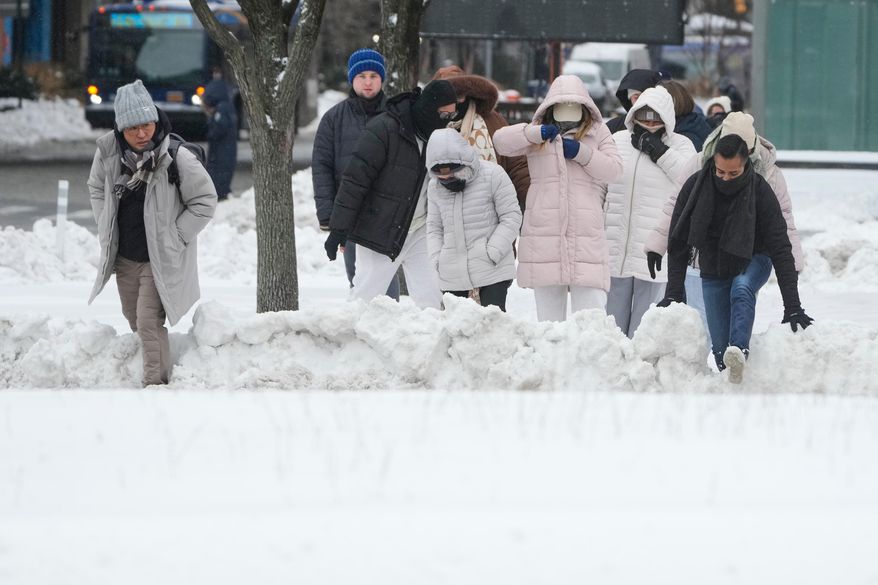Pedestrians climb over snow banks to try and cross the streets in New York, Monday, Jan. 26, 2026. (AP Photo/Seth Wenig, File)