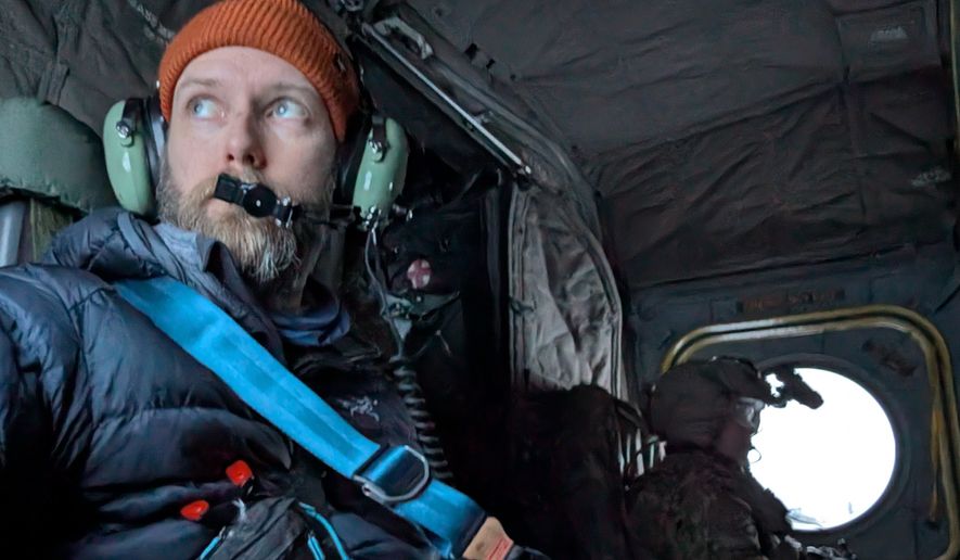 John T. Seward prepares for lift off with the 1-52 General Support Aviation Battalion in a Chinhook helicopter to observe an Air Assault mission. The mission infiltrated four snow mobiles and heavy sleds with supplies and equipment across the battlefield.