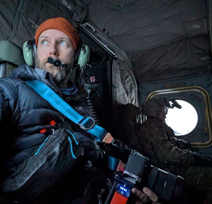 John T. Seward prepares for lift off with the 1-52 General Support Aviation Battalion in a Chinhook helicopter to observe an Air Assault mission. The mission infiltrated four snow mobiles and heavy sleds with supplies and equipment across the battlefield.