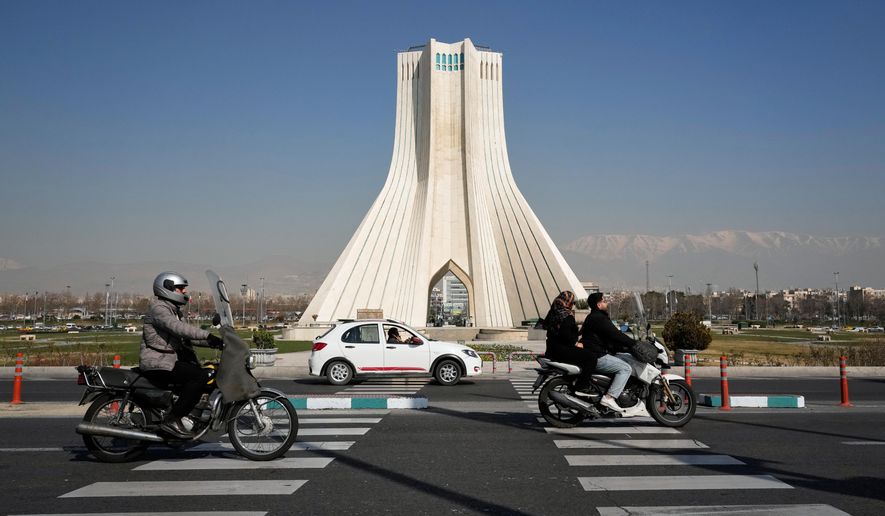 Vehicles drive by the Azadi (Freedom) monument in Tehran, Iran, Sunday, Feb. 22, 2026.(AP Photo/Vahid Salemi)