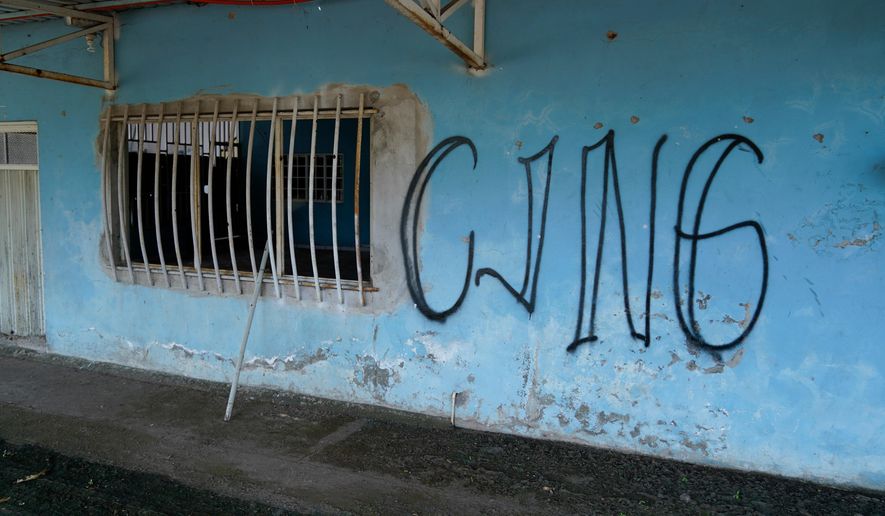The letters "CJNG" for the group's formal name, Jalisco New Generation Cartel, covers the facade of an abandoned home in El Limoncito, in the Michoacan state of Mexico, Oct. 30, 2021. (AP Photo/Eduardo Verdugo, File)