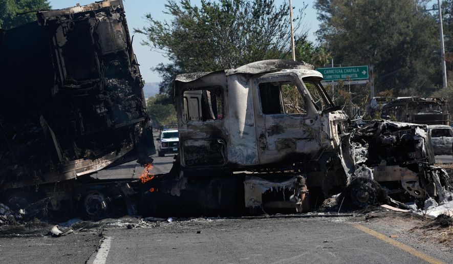 A charred truck blocks a road the day after the Mexican army killed Jalisco New Generation Cartel leader Nemesio Oseguera Cervantes, known as "El Mencho," in Guadalajara, Mexico, Monday, Feb. 23, 2026. (AP Photo/Marco Ugarte)