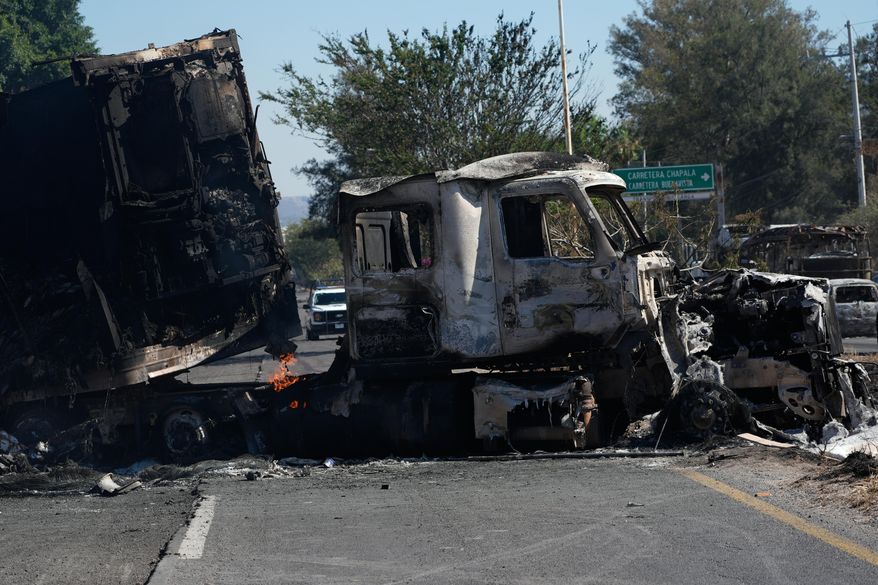 A charred truck blocks a road the day after the Mexican army killed Jalisco New Generation Cartel leader Nemesio Oseguera Cervantes, known as "El Mencho," in Guadalajara, Mexico, Monday, Feb. 23, 2026. (AP Photo/Marco Ugarte)