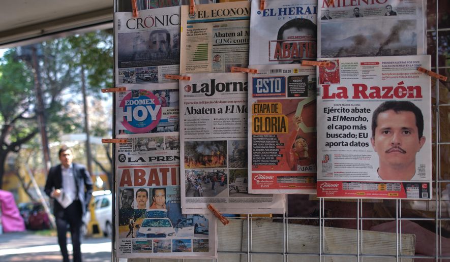 Newspapers hang on display for sale in Mexico City, Monday, Feb. 23, 2026, a day after the Mexican army killed Jalisco New Generation Cartel leader Nemesio Oseguera Cervantes, known as "El Mencho." (AP Photo/Jon Orbach)