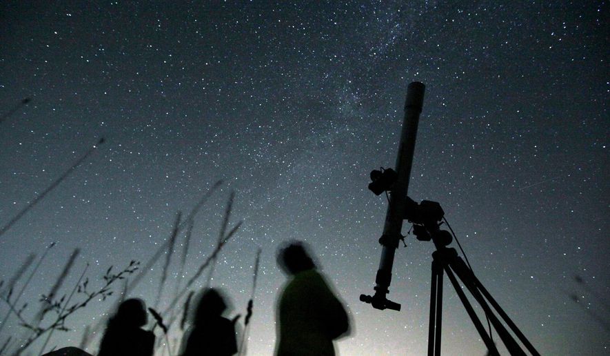 FILE - People look up to the sky from an observatory near the village of Avren, Bulgaria, Aug. 12, 2009. (AP Photo/Petar Petrov, File)