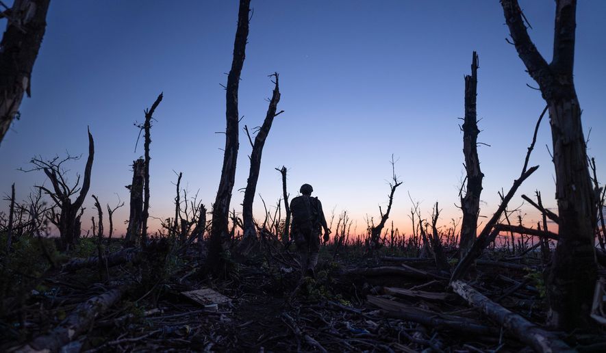 Ukrainian servicemen walk through a charred forest at the frontline a few kilometers from Andriivka, Donetsk region, Ukraine, Saturday, Sept. 16, 2023. (AP Photo/Mstyslav Chernov, File)