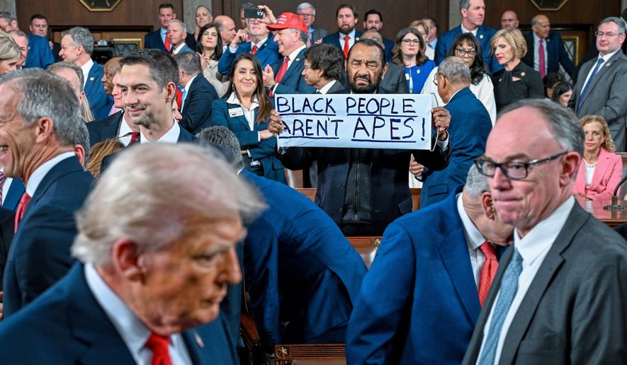 Rep. Al Green, D-Texas, holds up a sign as President Donald J. Trump walks by on his way to deliver the State of the Union address to a joint session of Congress in the House chamber at the U.S. Capitol in Washington, Tuesday, Feb. 24, 2026. (Kenny Holston/The New York Times via AP, Pool)