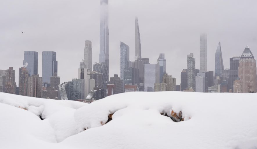 A piece of the New York skyline rises above a pile of snow on the Weekhawken, N.J. waterfront, Monday, Feb. 23, 2026. (AP Photo/Seth Wenig)