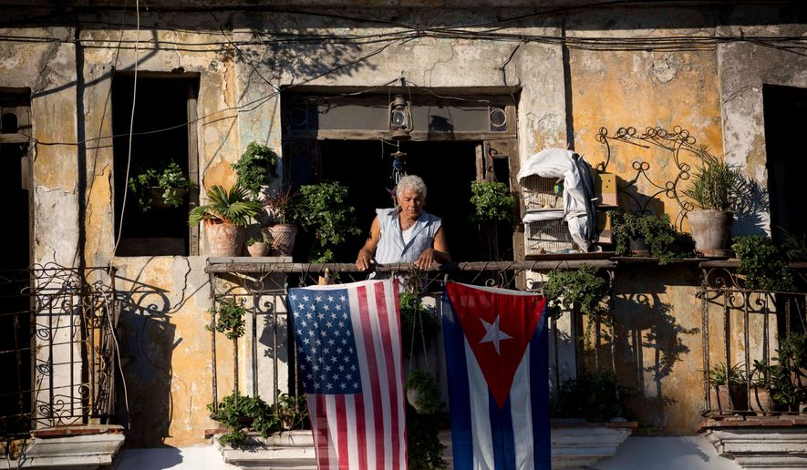 Javier Yanez stands on his balcony where he hung a U.S. and Cuban flag in Old Havana Cuba on Friday, Dec. 19, 2014. (AP Photo/Ramon Espinosa) **FILE**