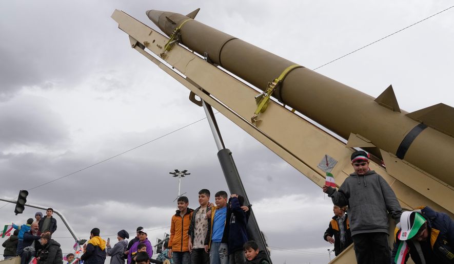 Boys stand on a launcher of an Iranian domestically-built missile during an annual rally marking 1979 Islamic Revolution at the Azadi (Freedom) sq. in Tehran, Iran, Wednesday, Feb. 11, 2026. (AP Photo/Vahid Salemi)