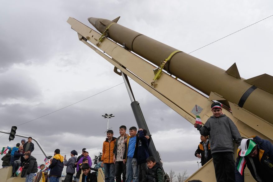 Boys stand on a launcher of an Iranian domestically-built missile during an annual rally marking 1979 Islamic Revolution at the Azadi (Freedom) sq. in Tehran, Iran, Wednesday, Feb. 11, 2026. (AP Photo/Vahid Salemi)