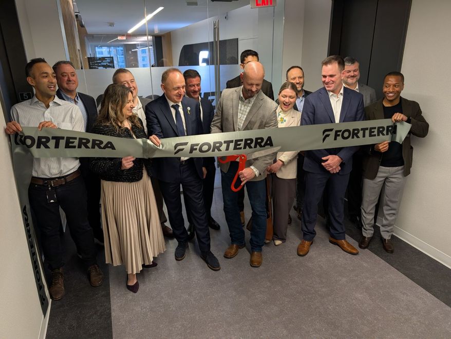 Colin Chisholm, the chief operations officer of Forterra, cuts the ribbon at a Feb. 25 ceremony opening the defense firm's new office in Arlington, Virginia. (John T. Seward/The Washington Times)