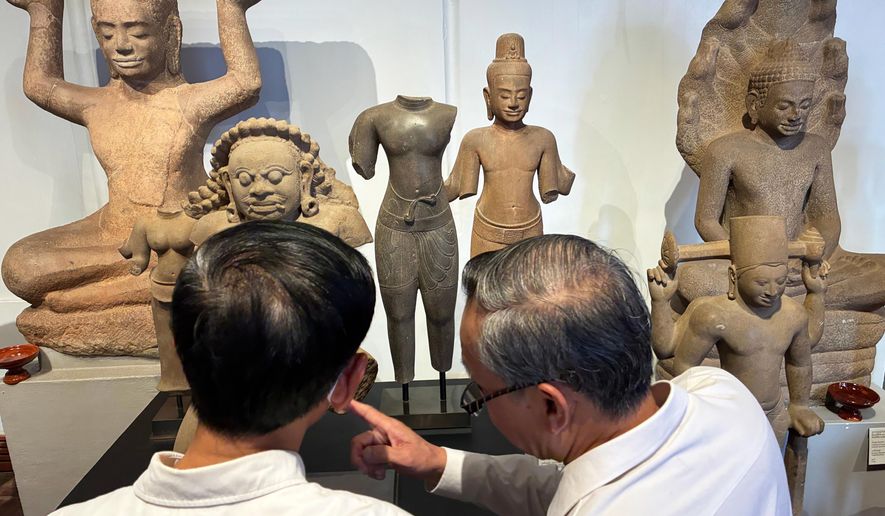 Cambodian officials look at Khmer cultural artifacts that were returned to the country, at the National Museum, in Phnom Penh, Friday, Feb. 27, 2026. (AP Photo/Sopheng Cheang)