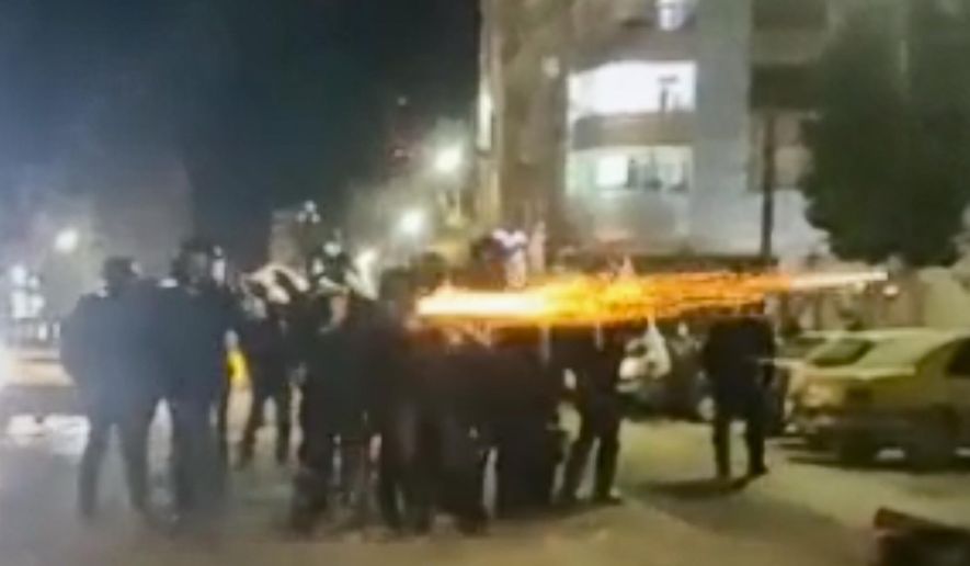 This image from a video verified by AP shows Iranian security forces shooting into the courtyard outside the Imam Khomeini Hospital, in Ilam, Iran, Jan. 4, 2026. (UGC via AP, File)