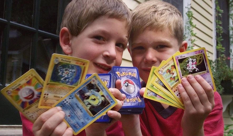 FILE - Tyler, right, and his friend George, hold up their favorite Pokemon trading cards, in Scituate, Mass., Sept. 9, 1999. (AP Photo/Charles Krupa, File)