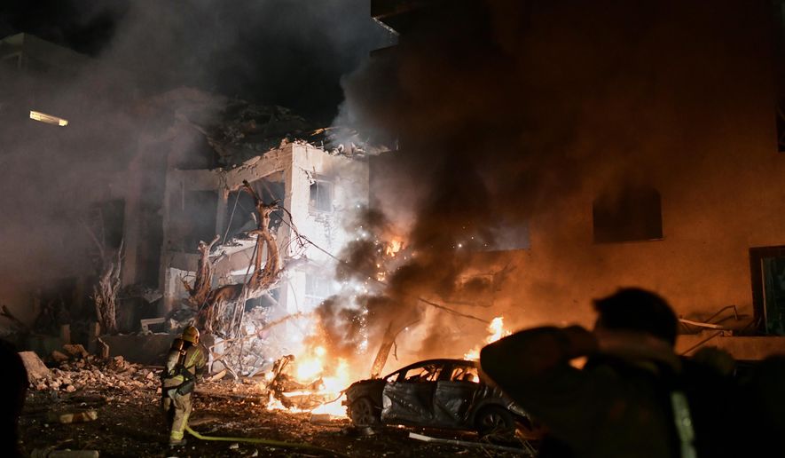Firefighters try to extinguish flames in a building after a direct hit by an Iranian missile strike in Tel Aviv, Israel, Saturday, Feb. 28, 2026. (AP Photo/Tomer Neuberg)