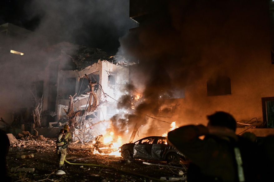 Firefighters try to extinguish flames in a building after a direct hit by an Iranian missile strike in Tel Aviv, Israel, Saturday, Feb. 28, 2026. (AP Photo/Tomer Neuberg)