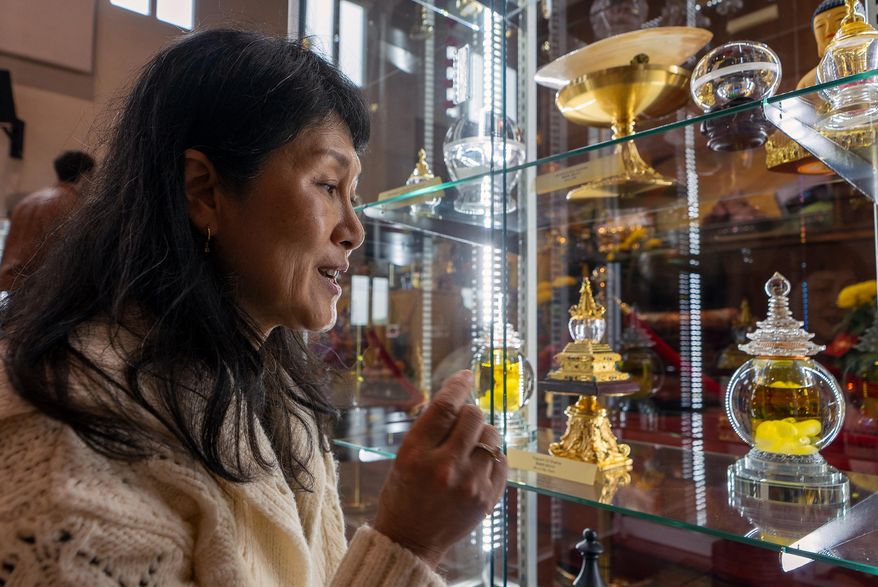 Buddhist practitioner and disciple of Master YongHua, Sarah Kim, shows the Fragrant Oil Shariras among other Buddhist relics displayed at Wei Mountain Temple, in Rosemead, Calif., Saturday, Feb. 17, 2024. (AP Photo/Damian Dovarganes)