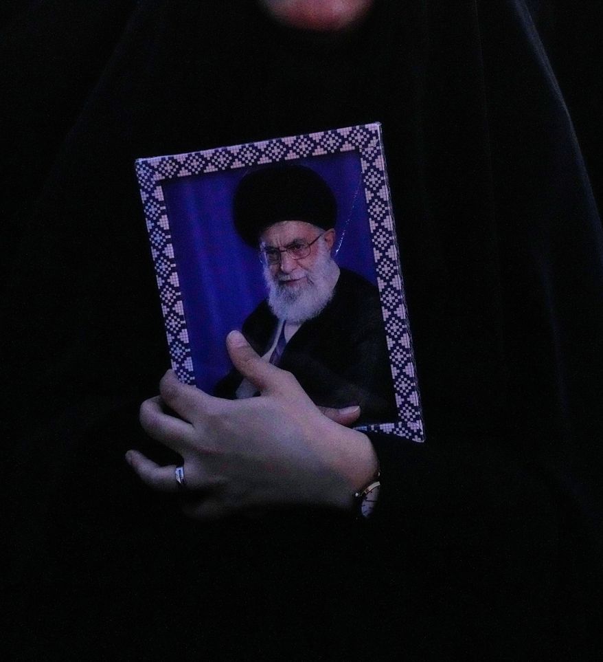 A government supporter holds a picture of the Iranian Supreme Leader Ayatollah Ali Khamenei during a gathering after state TV officially announced the death of Khamenei, in Tehran, Iran, Sunday, March 1, 2026. (AP Photo/Vahid Salemi)