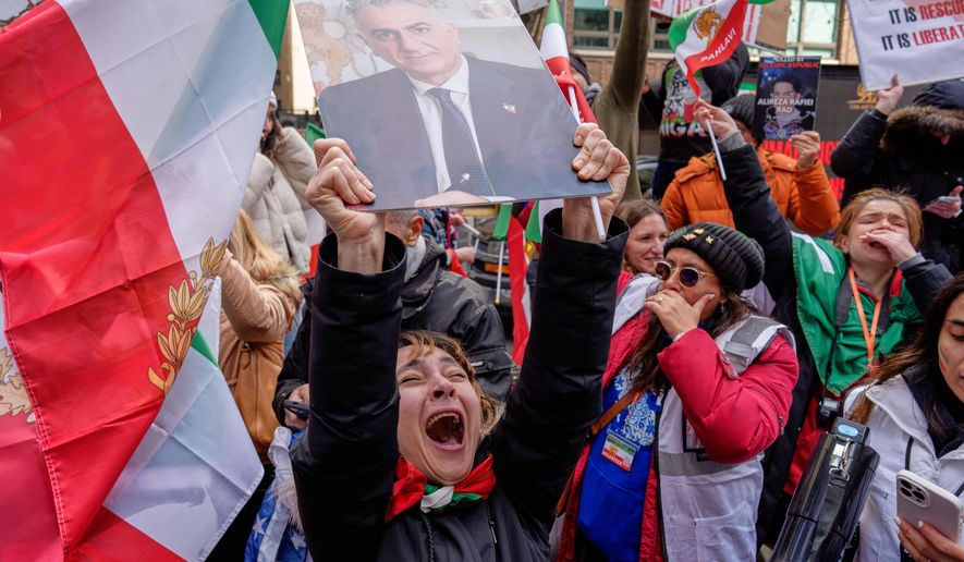 A person holds an image of Reza Pahlavi during a rally in reaction to U.S. and Israeli strikes on Iran and in support of Pahlavi, the exiled son of Iran’s last shah overthrown during the 1979 Islamic Revolution, in New York on Sunday, March 1, 2026. (AP Photo/Adam Gray) **FILE**