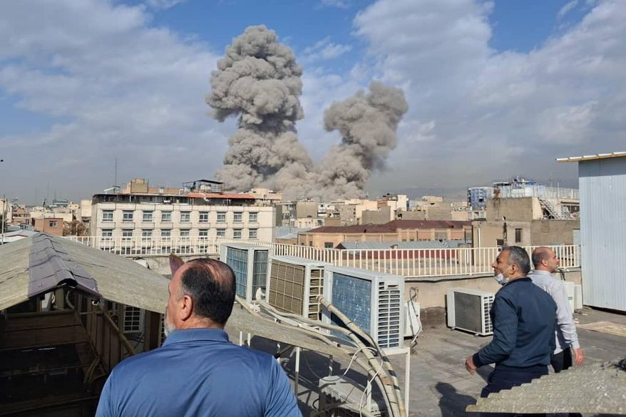 People watch as smoke rises on the skyline after an explosion in Tehran, Iran, Feb. 28, 2026. (AP Photo, File)