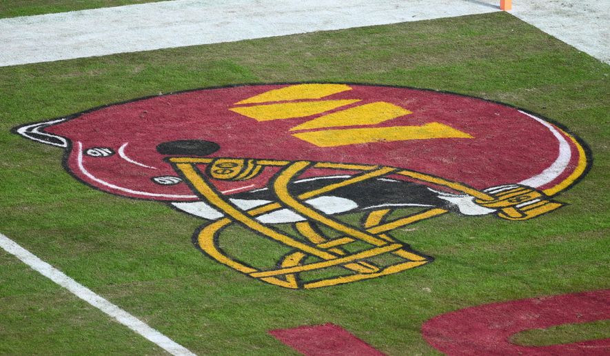 Washington Commanders helmet logo on the field before an NFL football game between the Washington Commanders and the Dallas Cowboys, Dec. 25, 2025, in Landover, Md. (AP Photo/Nick Wass, file)