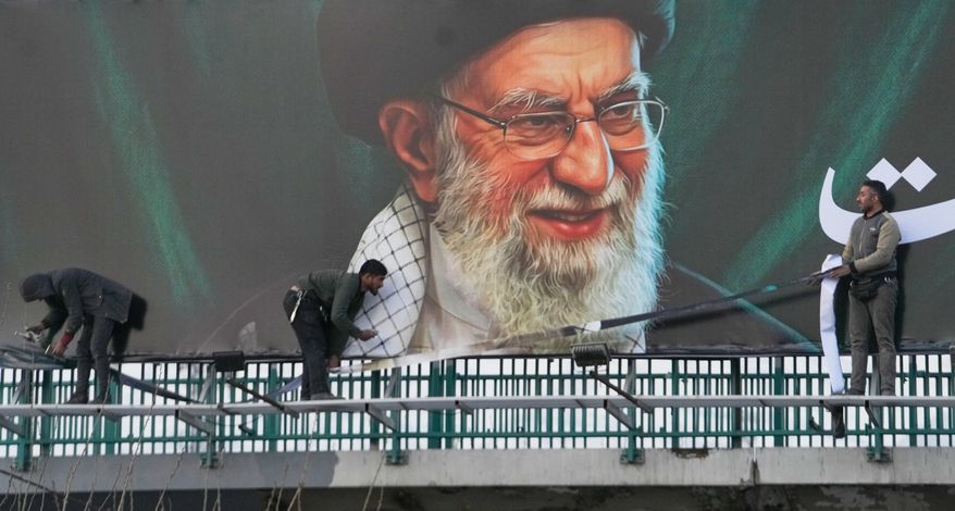 Workers install a billboard on an overpass containing a portrait of the late Iranian Supreme Leader Ayatollah Ali Khamenei, who was killed during ongoing joint U.S.-Israeli military attacks, in Tehran, Iran, Monday, March 2, 2026. (AP Photo/Vahid Salemi)