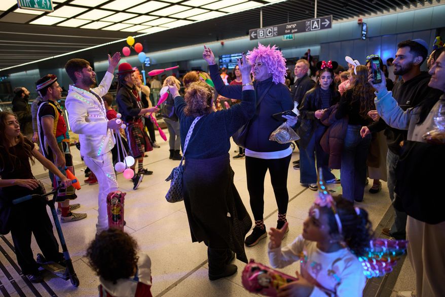 People, some wearing costumes, celebrate the Jewish holiday of Purim in an underground metro station used as a shelter against possible Iranian missile attacks, in Ramat Gan, Israel, Monday, March 2, 2026. (AP Photo/Oded Balilty)