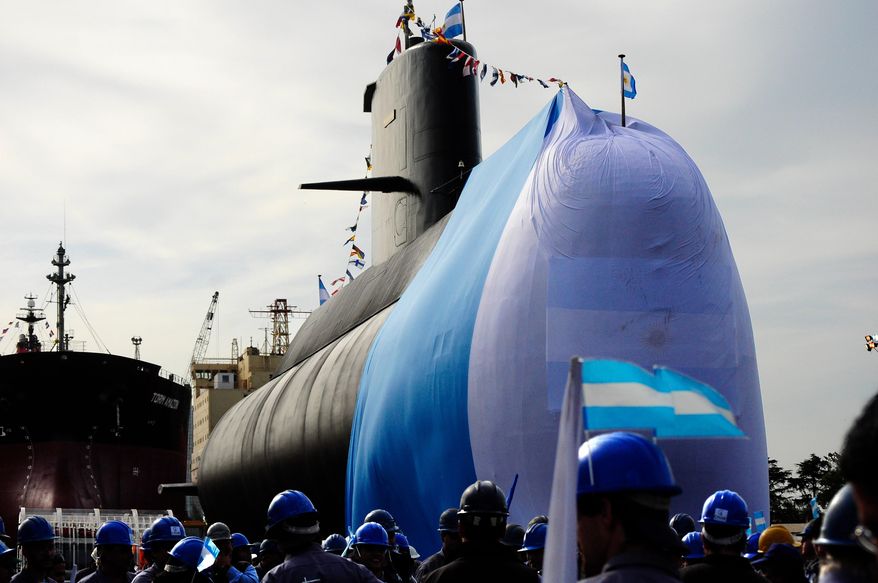 FILE - Workers stand around the ARA San Juan submarine during a ceremony celebrating the first stage of major repairs at the Argentine Industrial Naval Complex (CINAR) in Buenos Aires, Sept. 27, 2011. (AP Photo/Mario de Fina, File)