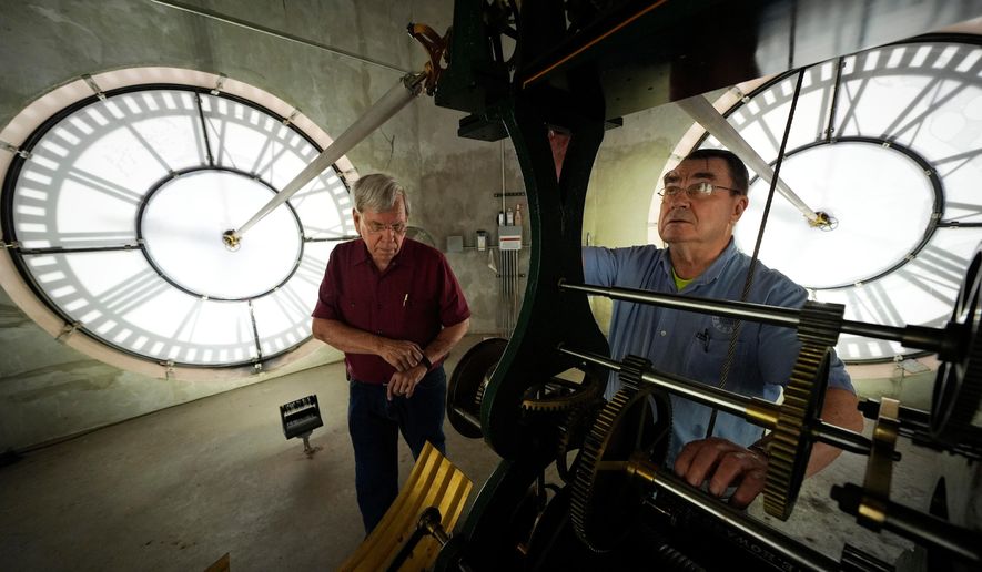 Chuck Roeser (right) and Don Bugh set the time forward on the historic clock tower atop the Dallas County Courthouse in Dallas on March 7, 2024. The mechanical clock built in 1890 requires hand lubrication and reseting twice a year with daylight savings time. (AP Photo/LM Otero) **FILE**
