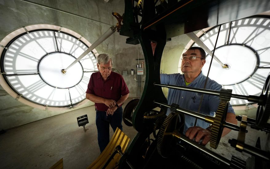 Chuck Roeser (right) and Don Bugh set the time forward on the historic clock tower atop the Dallas County Courthouse in Dallas on March 7, 2024. The mechanical clock built in 1890 requires hand lubrication and reseting twice a year with daylight savings time. (AP Photo/LM Otero) **FILE**