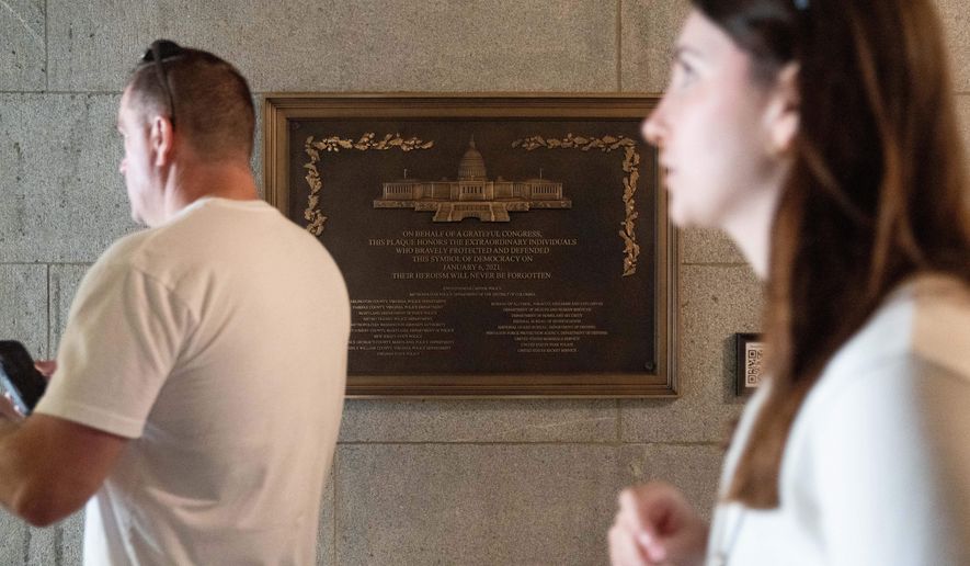 A tour group walks by a plaque honoring police service on Jan. 6, 2021 at the Capitol, Saturday, March 7, 2026, in Washington. (AP Photo/Allison Robbert)