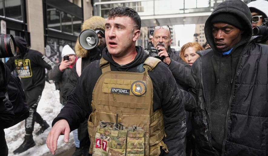 FILE - Jake Lang, center, walks away from counter protesters after an altercation near Minneapolis City Hall, Saturday, Jan. 17, 2026, in Minneapolis. (AP Photo/Yuki Iwamura,File)