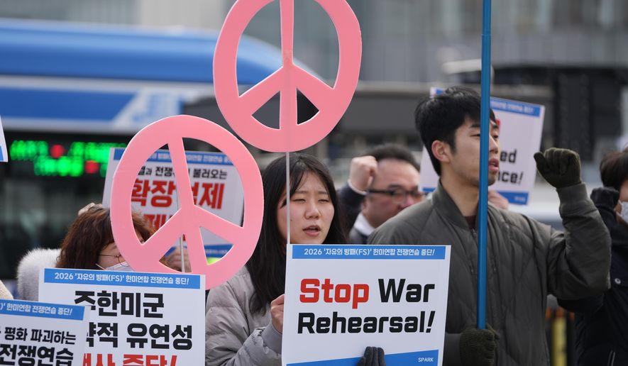 Protesters hold signs to oppose the joint military exercise between the U.S. and South Korea, near the U.S. Embassy in Seoul, South Korea, Monday, March 9, 2026. (AP Photo/Lee Jin-man)