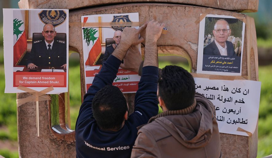 Family members of retired Lebanese officer Ahmed Shukr, hang posters of him during a gathering outside the headquarters of the U.N. Economic and Social Commission for Western Asia, ESCWA, in Beirut, Lebanon, Friday, Feb. 13, 2026. (AP Photo/Bilal Hussein)