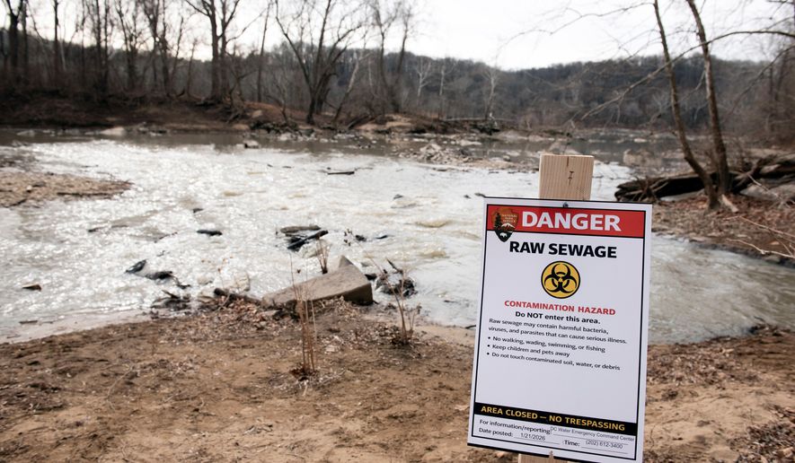 A warning sign is seen at the sight of a massive pipe rupture, as sewage flows into the Potomac River, right, in Glen Echo, Md., on Jan. 23, 2026. (AP Photo/Cliff Owen) **FILE**